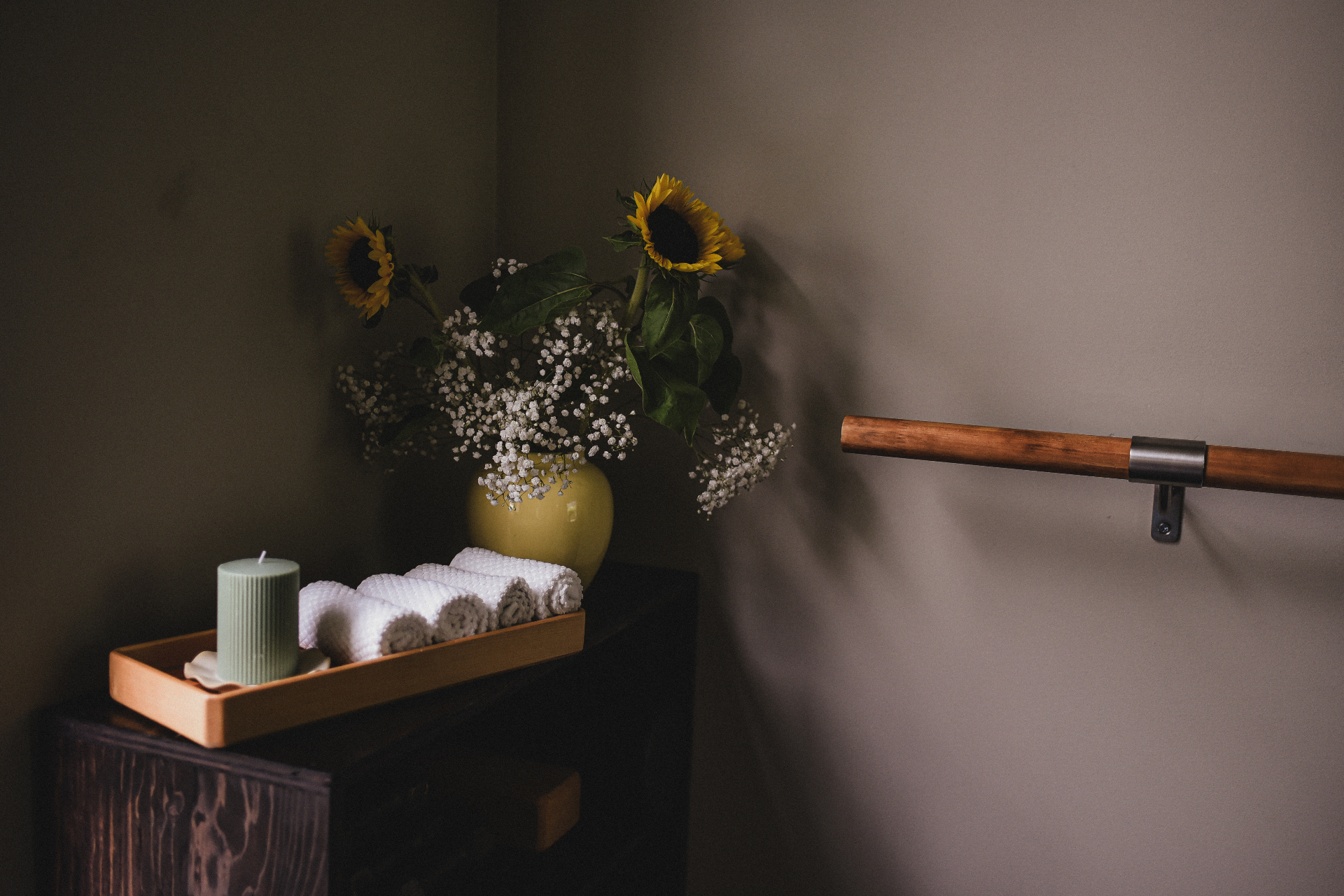 Studio details with fresh towels, candle and sunflowers by the barre