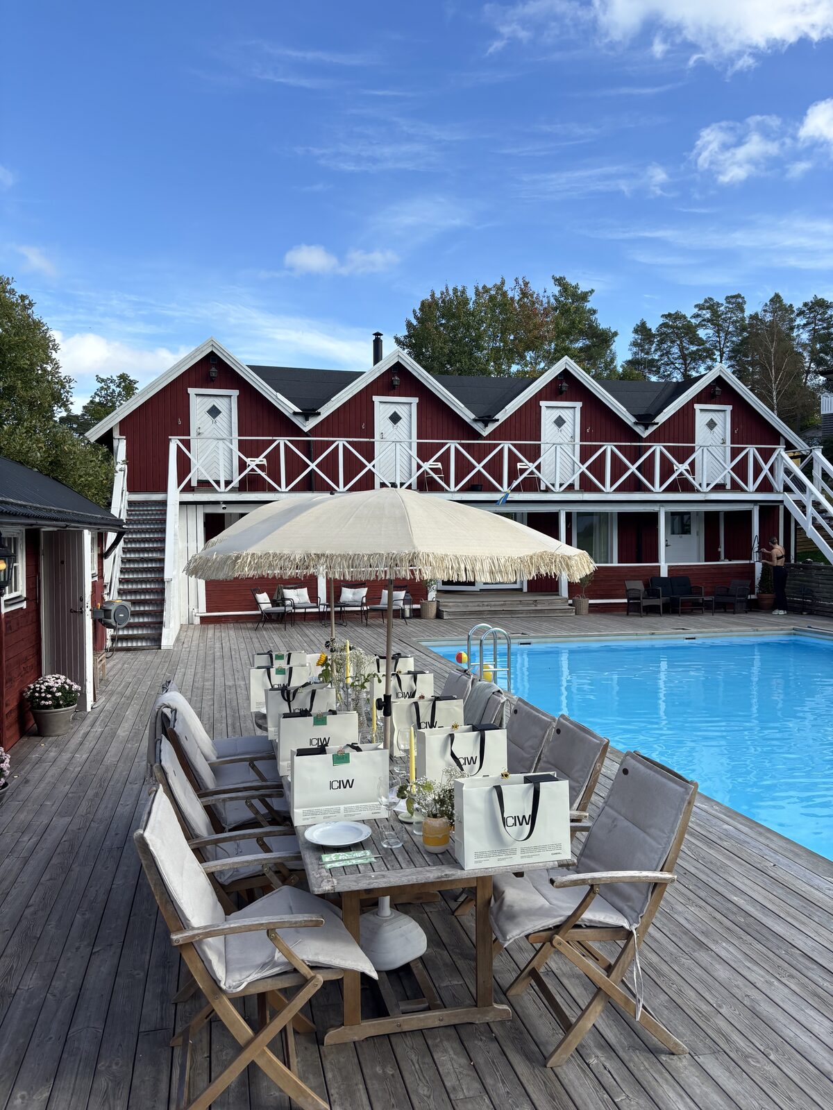 The long table set on the poolside deck, ready for guests