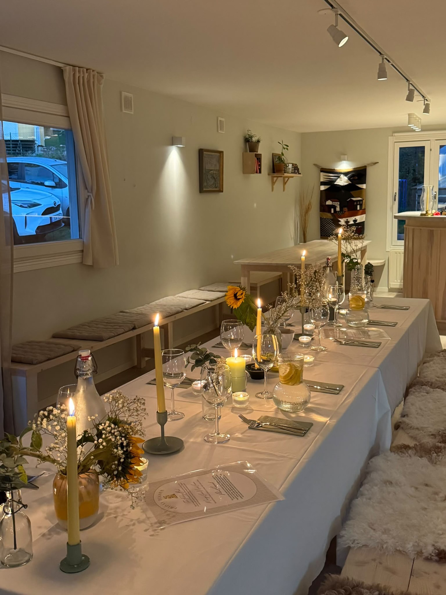 The candlelit long table dressed with flowers for dinner